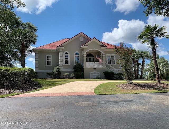 mediterranean / spanish-style house featuring covered porch and a front lawn