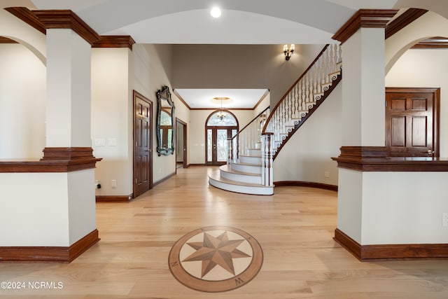 entryway with french doors, crown molding, and light hardwood / wood-style floors