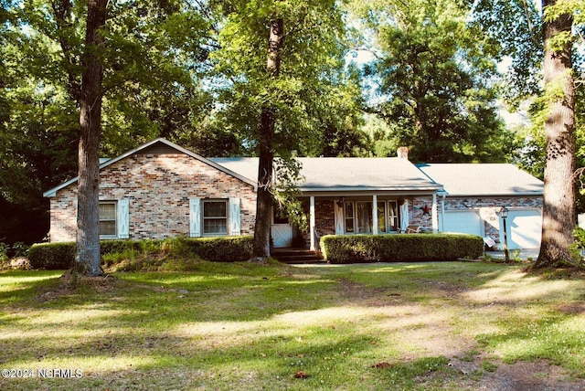 single story home featuring covered porch, a garage, and a front lawn