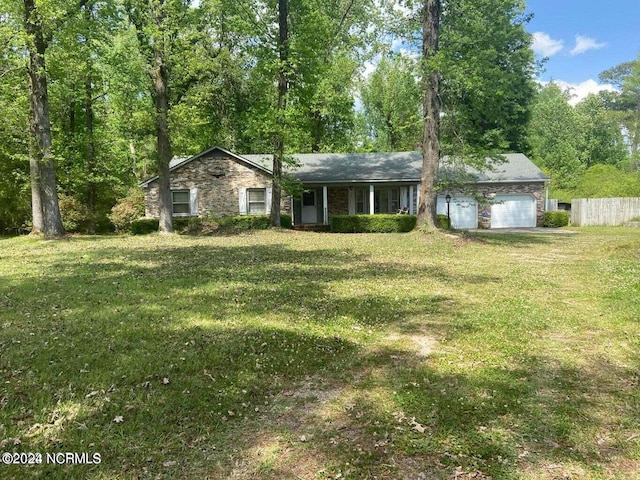 ranch-style house featuring a garage and a front lawn