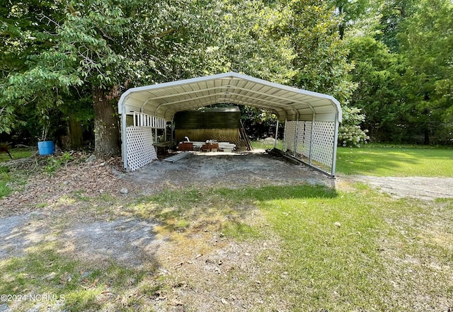 view of parking / parking lot with a carport and a yard