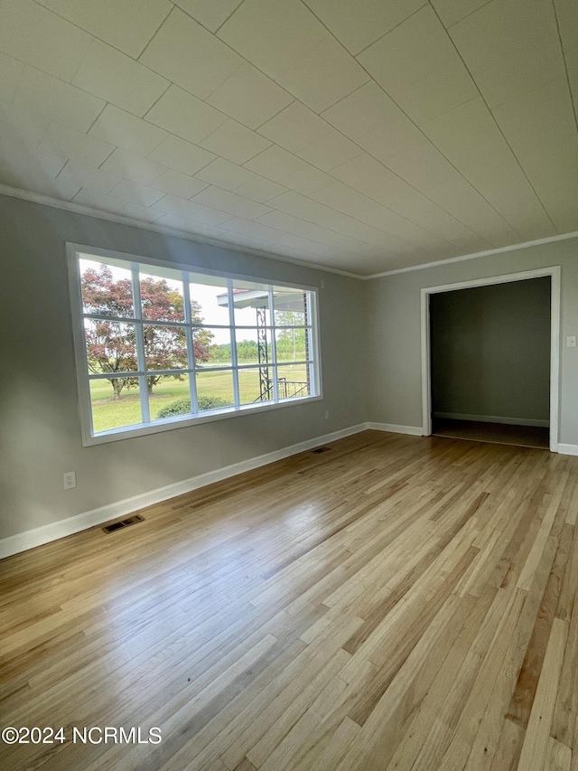 spare room with crown molding and light hardwood / wood-style floors