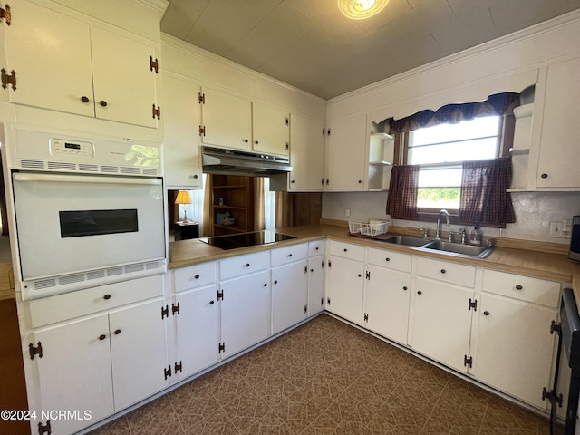 kitchen featuring white cabinetry, white oven, sink, and black electric cooktop