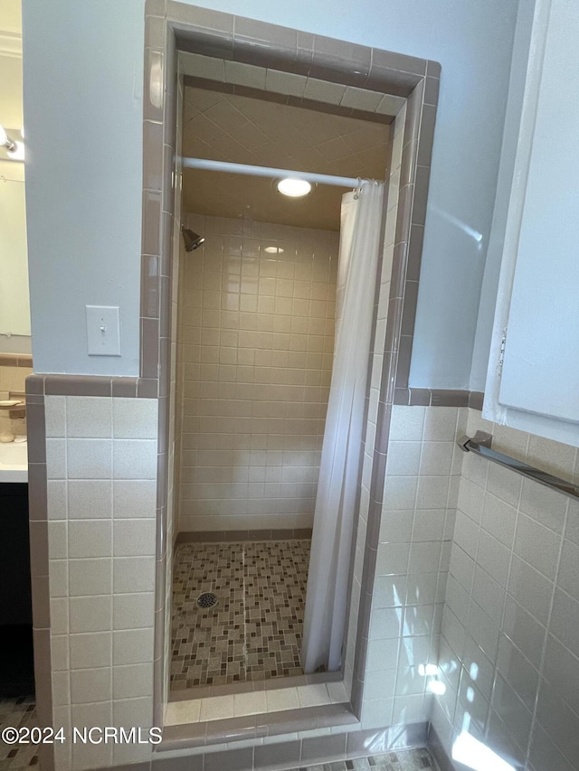 bathroom featuring vanity, tile walls, and a shower with shower curtain