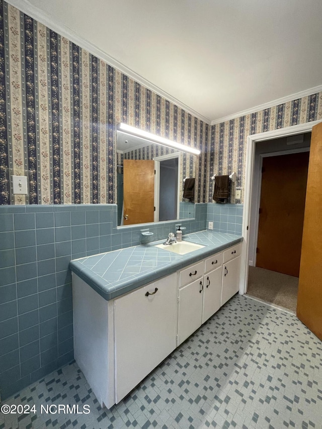 bathroom featuring crown molding, tile walls, and vanity