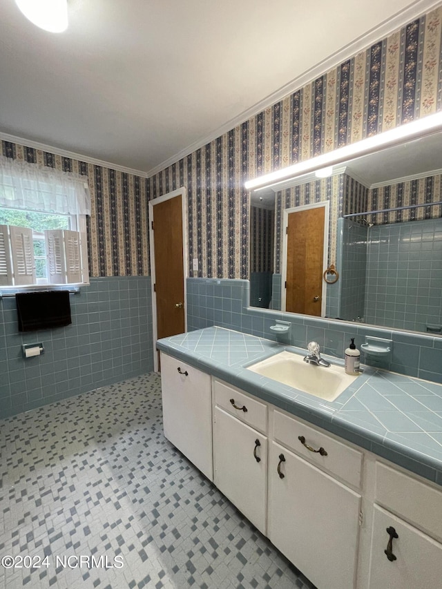 bathroom featuring crown molding, vanity, and tile walls