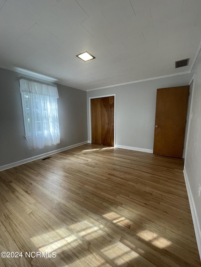 spare room with crown molding and light hardwood / wood-style floors