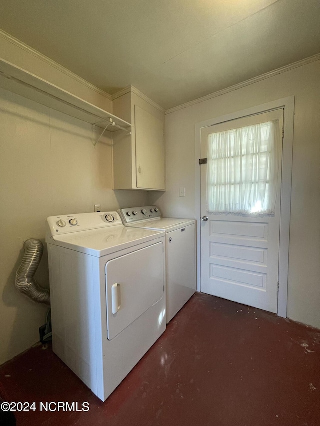 washroom featuring ornamental molding, cabinets, and washing machine and clothes dryer