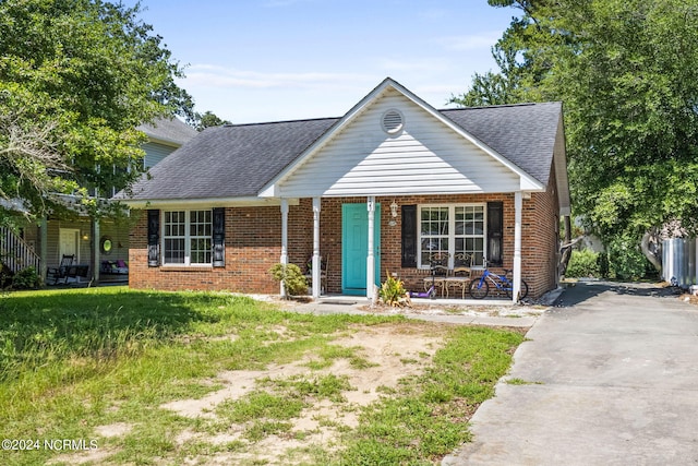 view of front of property with a porch and a front lawn