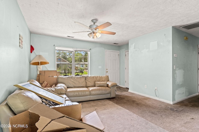 carpeted living room with ceiling fan and a textured ceiling