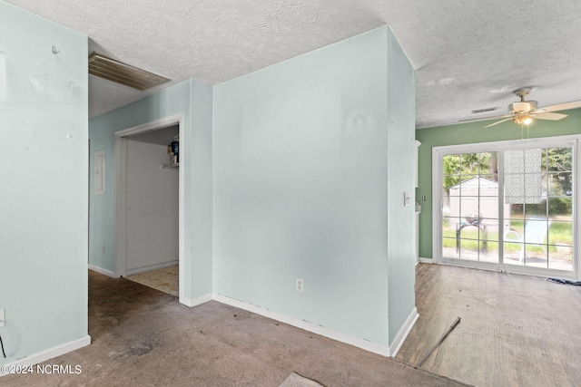 carpeted empty room featuring ceiling fan and a textured ceiling