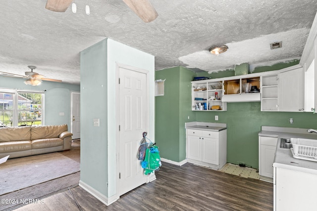 kitchen featuring white cabinets, ceiling fan, dark hardwood / wood-style floors, and a textured ceiling