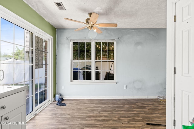 unfurnished sunroom with ceiling fan