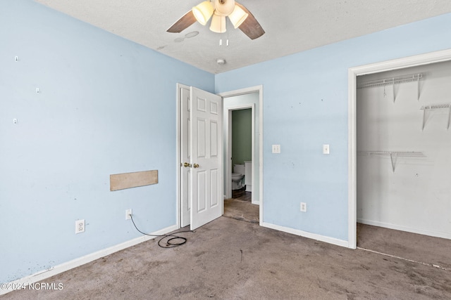 unfurnished bedroom with a textured ceiling, carpet, ceiling fan, and a closet