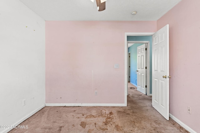 carpeted spare room featuring ceiling fan