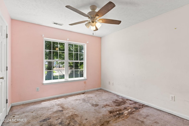 carpeted spare room with a textured ceiling and ceiling fan