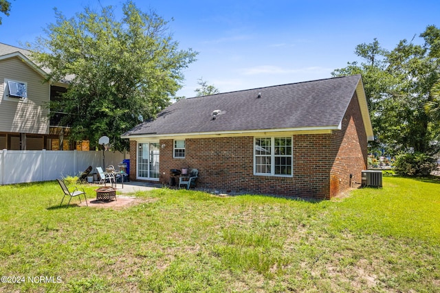 back of property featuring a yard, central AC unit, a patio area, and an outdoor fire pit