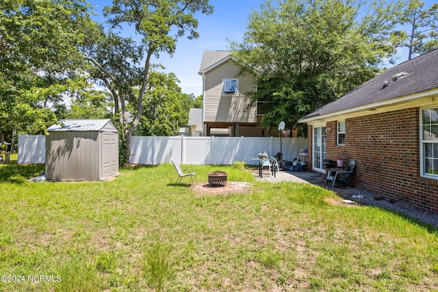 view of yard with a patio, a fire pit, and a storage shed