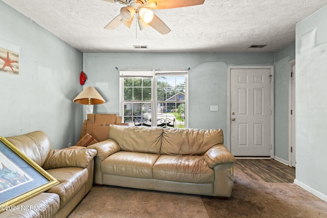 carpeted living room with ceiling fan and a textured ceiling