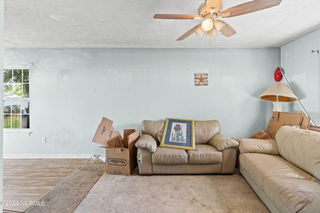 living room featuring a textured ceiling, ceiling fan, and light hardwood / wood-style floors