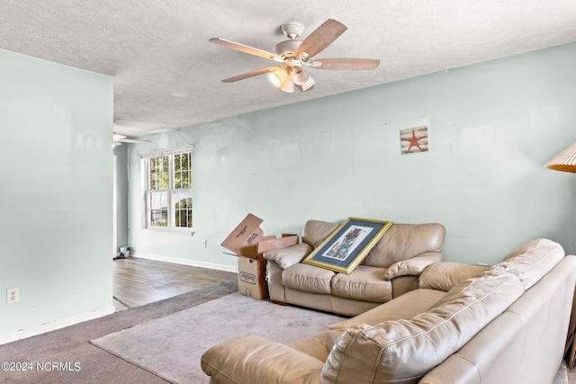 living room with a textured ceiling, ceiling fan, and wood-type flooring