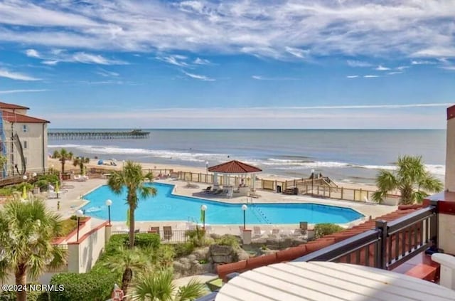 view of pool featuring a water view, a patio, and a gazebo