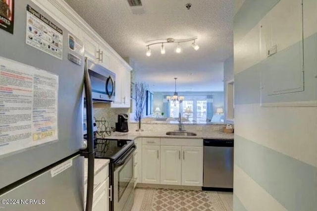 kitchen featuring white cabinetry, a chandelier, a textured ceiling, stainless steel appliances, and sink