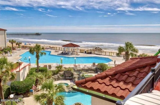 view of swimming pool with a patio area and a water view