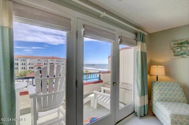 entryway featuring a water view, french doors, and a textured ceiling