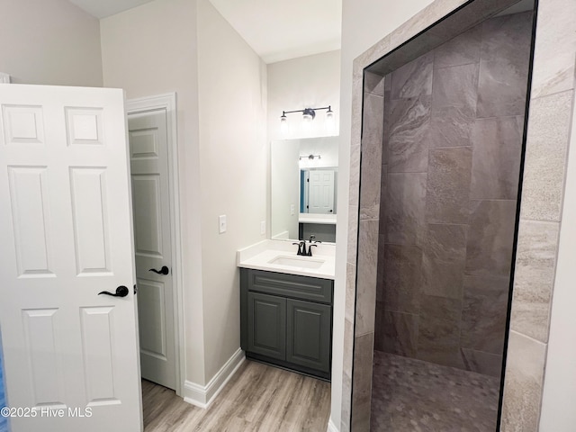 bathroom featuring tiled shower, vanity, and hardwood / wood-style flooring