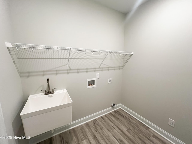 clothes washing area featuring electric dryer hookup, hardwood / wood-style flooring, hookup for a washing machine, and sink