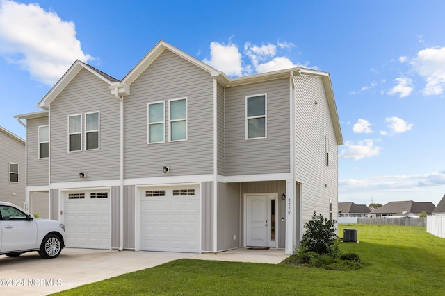 view of front facade featuring cooling unit, a garage, and a front lawn