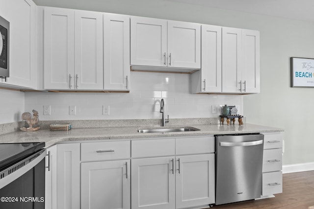 kitchen featuring white cabinets, backsplash, stainless steel appliances, wood-type flooring, and sink