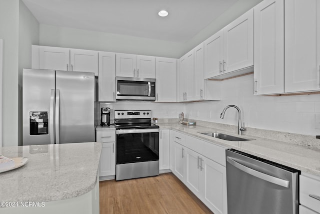 kitchen featuring sink, light hardwood / wood-style flooring, stainless steel appliances, and white cabinetry