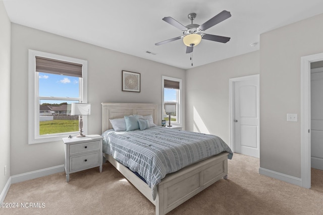 bedroom with ceiling fan and light colored carpet