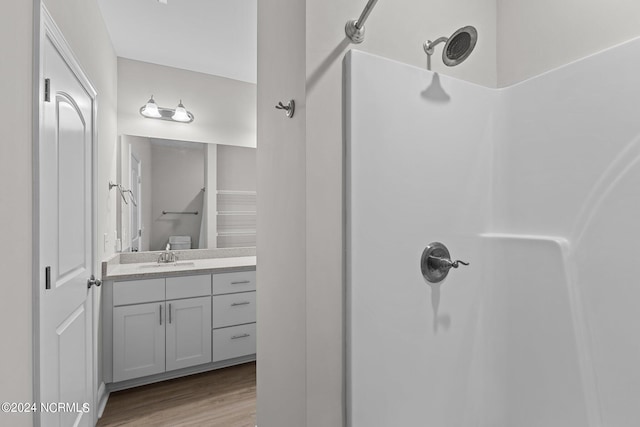 bathroom with a shower, vanity, and hardwood / wood-style floors