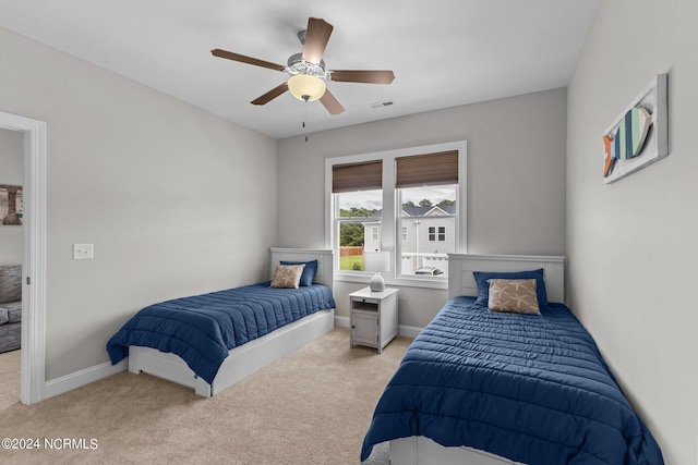 bedroom featuring light carpet and ceiling fan