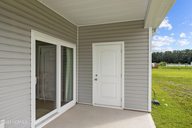 entrance to property with a lawn