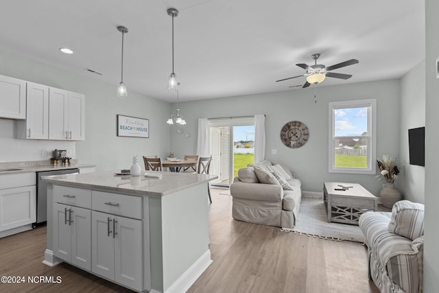 kitchen with decorative light fixtures, stainless steel dishwasher, hardwood / wood-style flooring, ceiling fan with notable chandelier, and white cabinets