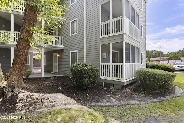 view of home's exterior with a sunroom