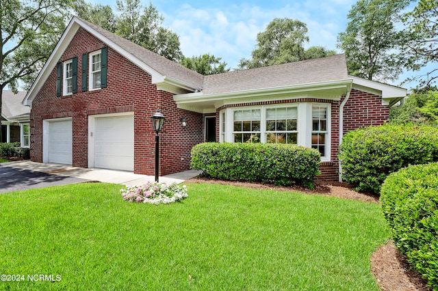 view of front of house featuring a garage and a front lawn