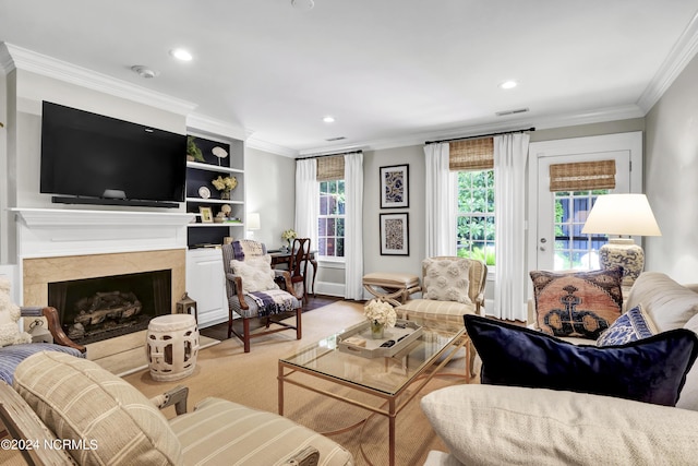 living area with recessed lighting, visible vents, crown molding, and a premium fireplace