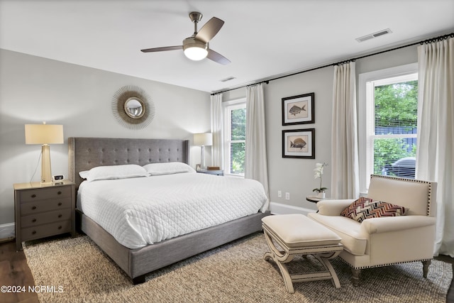 bedroom with baseboards, visible vents, ceiling fan, and wood finished floors