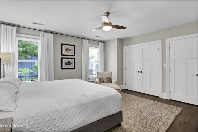 bedroom featuring dark wood-style floors, multiple windows, and visible vents