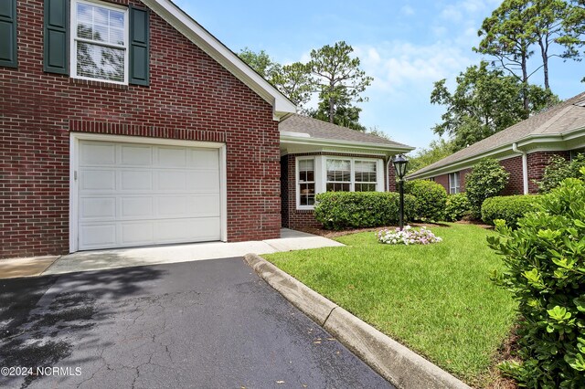 view of front of property with a front yard and a garage