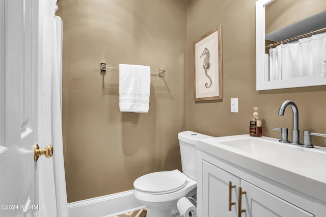 full bathroom with toilet, a shower with shower curtain, vanity, and baseboards