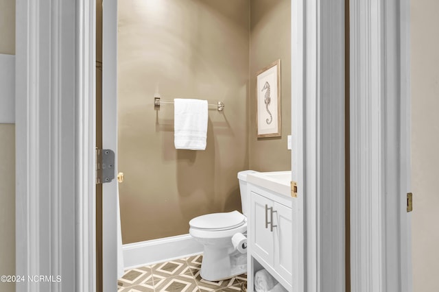 bathroom with baseboards, vanity, and toilet