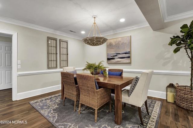 dining space with dark wood-type flooring, visible vents, crown molding, and baseboards