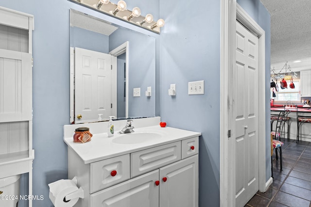 bathroom featuring vanity, a textured ceiling, and tile patterned flooring