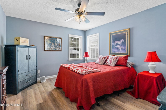 bedroom with a textured ceiling, ceiling fan, and wood-type flooring